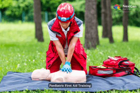 Emergency responder demonstrating CPR on a training manikin during Paediatric First Aid Training outdoors.