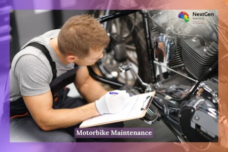 A man is working on a motorbike in a workshop, holding a pen and paper. He appears focused as he inspects the motorcycle, possibly taking notes or planning repairs. The background shows various tools and parts, suggesting a well-equipped garage setting.