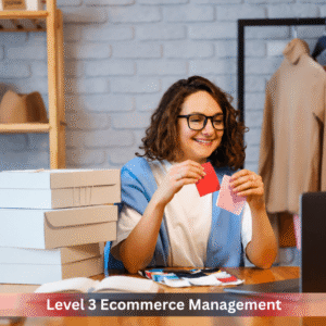 Level 3 Ecommerce Management student learning online while organising products for an ecommerce business with a laptop and packaging boxes.