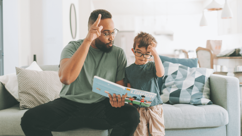 Adult and child using sign language together while reading a book at home.