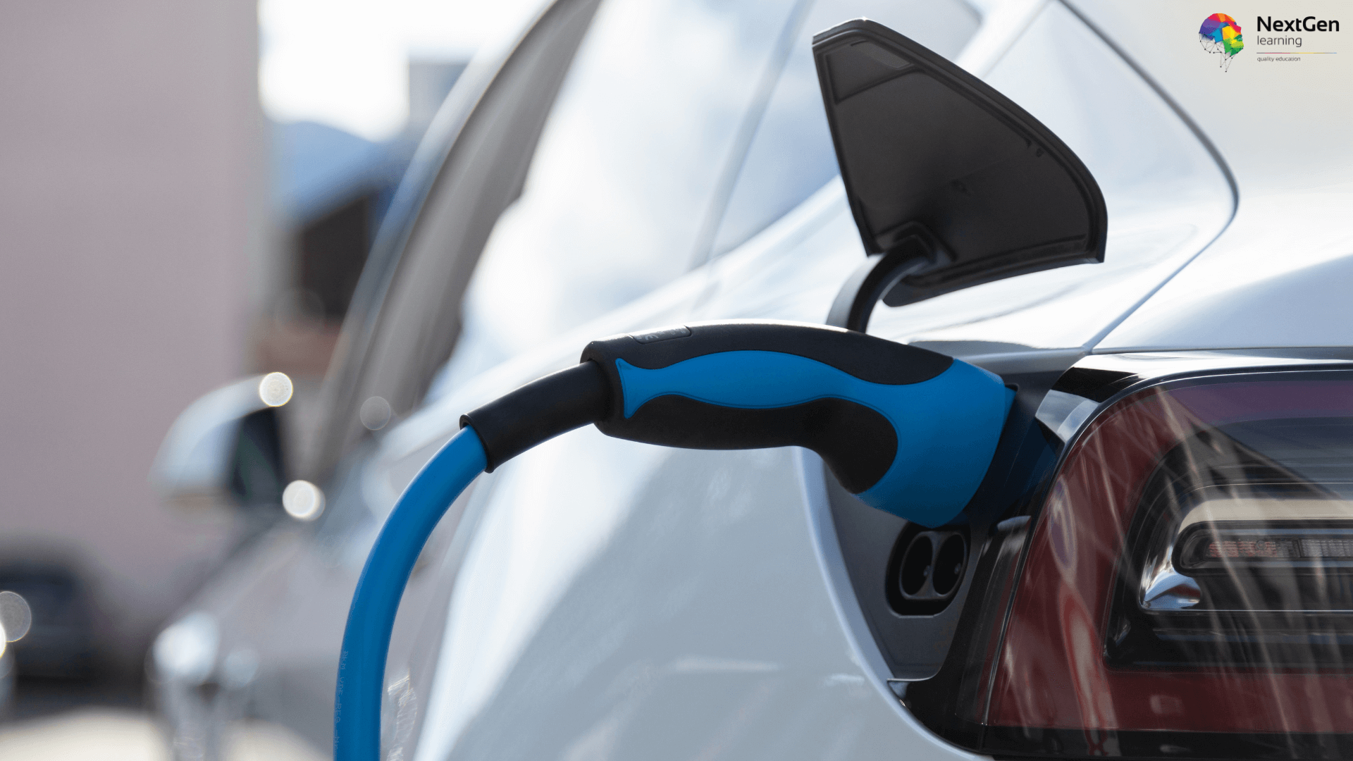 Electric vehicle charging with a blue and black EV charging cable plugged into a white car.