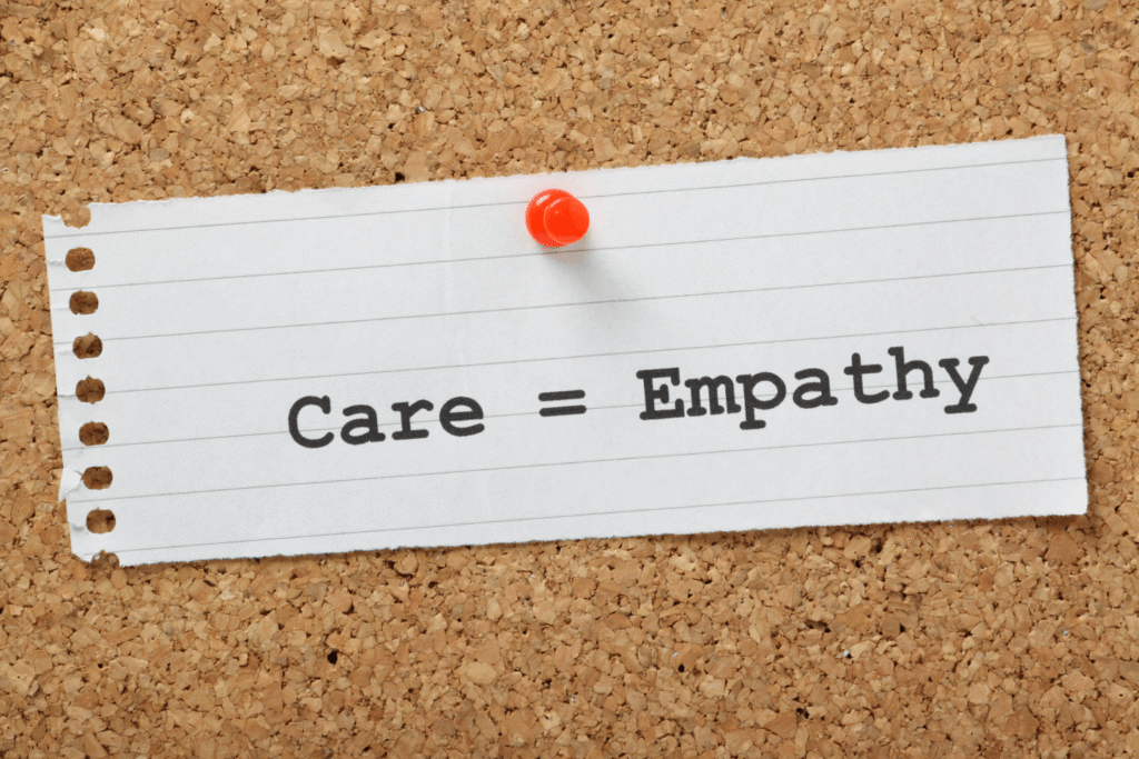 Image showing a simple message “Care = Empathy” pinned to a corkboard, symbolising how empathy strengthens client relationships by fostering trust, understanding, compassion, and meaningful professional connections.